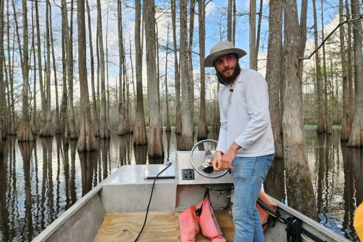 a man standing next to a fence
