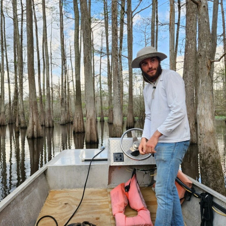 a man standing next to a fence