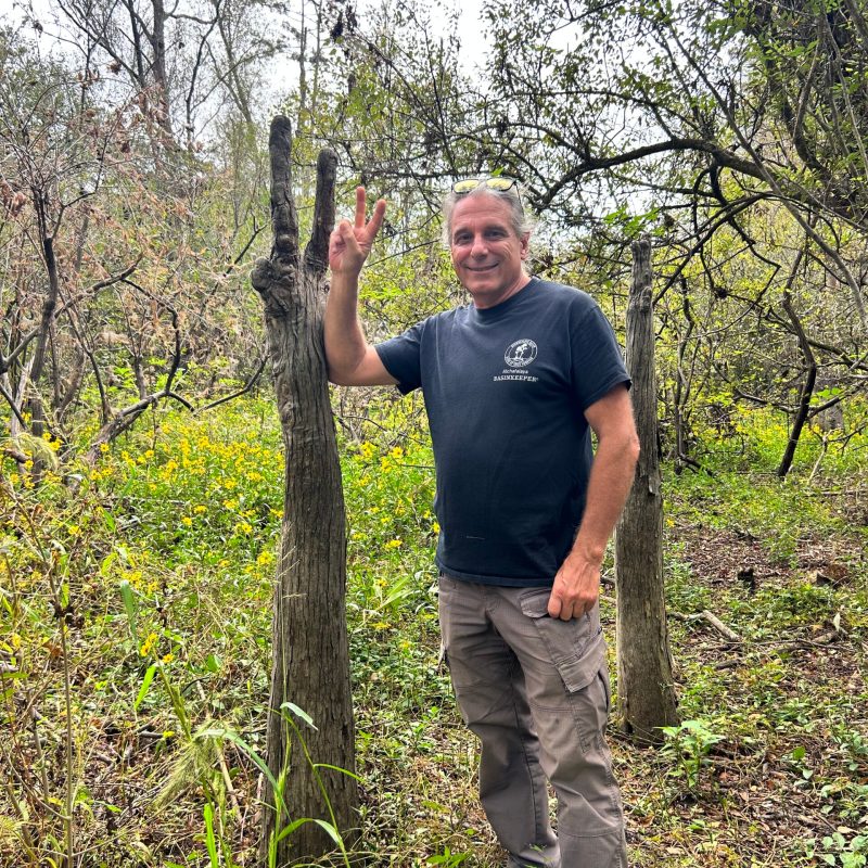 a man standing in front of a tree