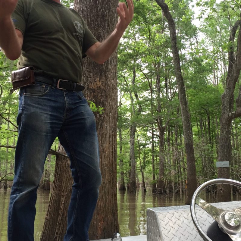 a man standing next to a tree