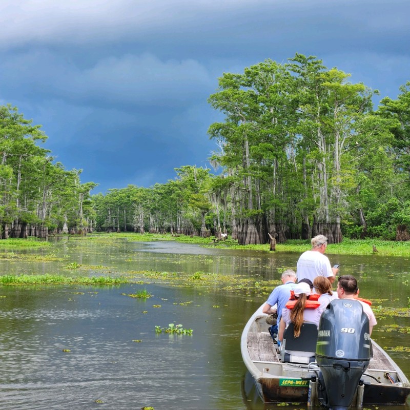 a group of people riding on the back of a boat in the water