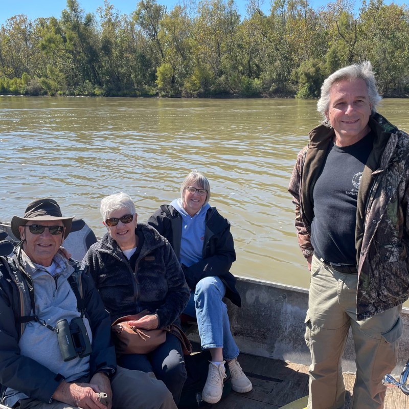 a group of people standing next to a lake