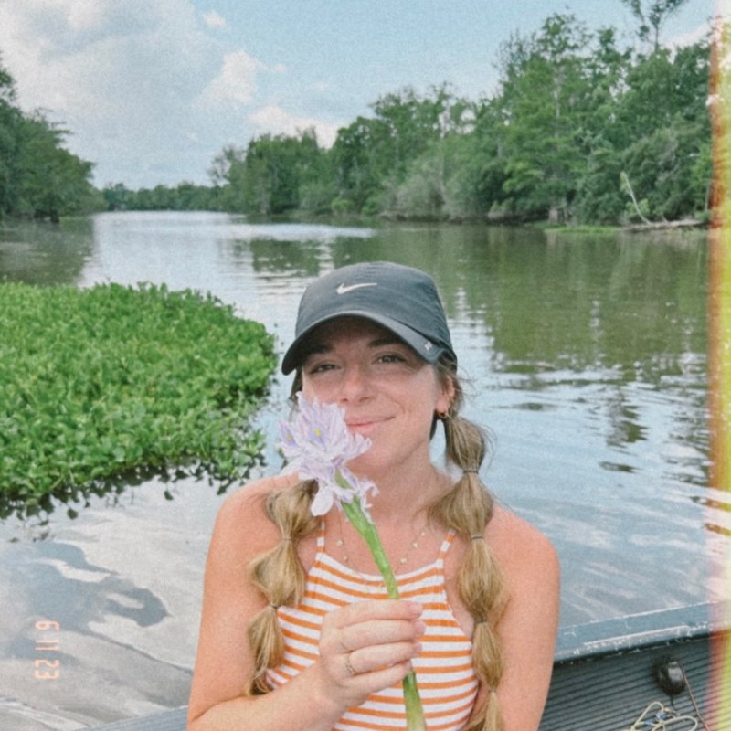 a person drinking water from a lake