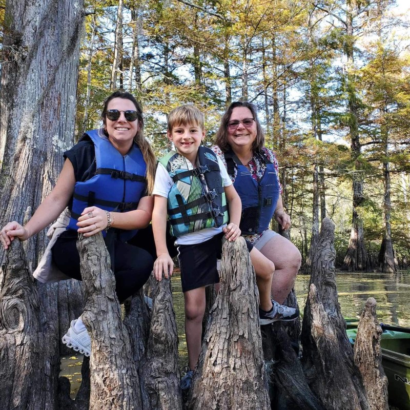 a group of people standing in front of a tree posing for the camera