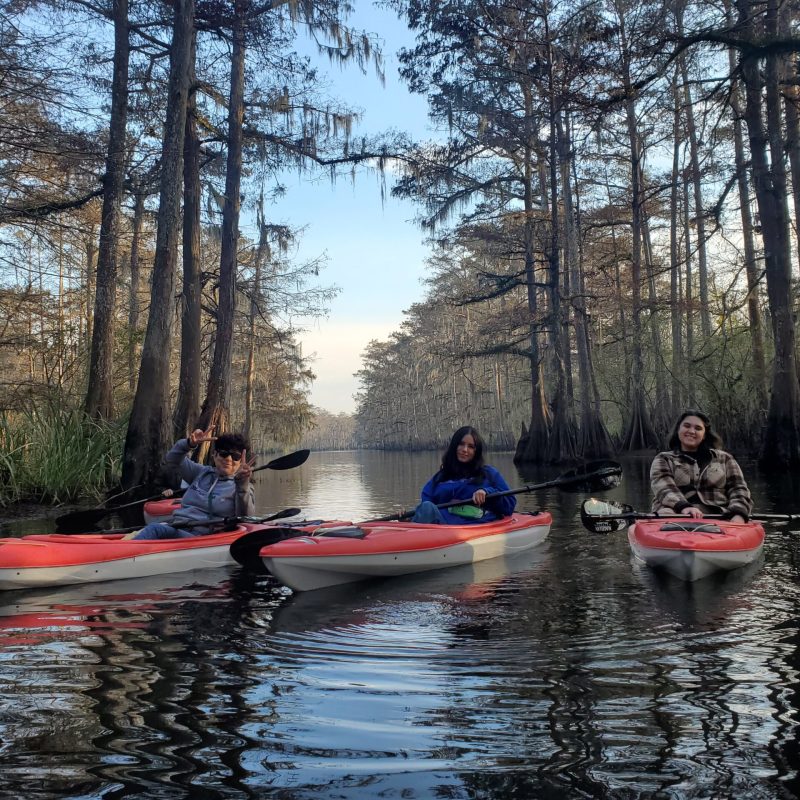 a group of people riding on the back of a boat in the water